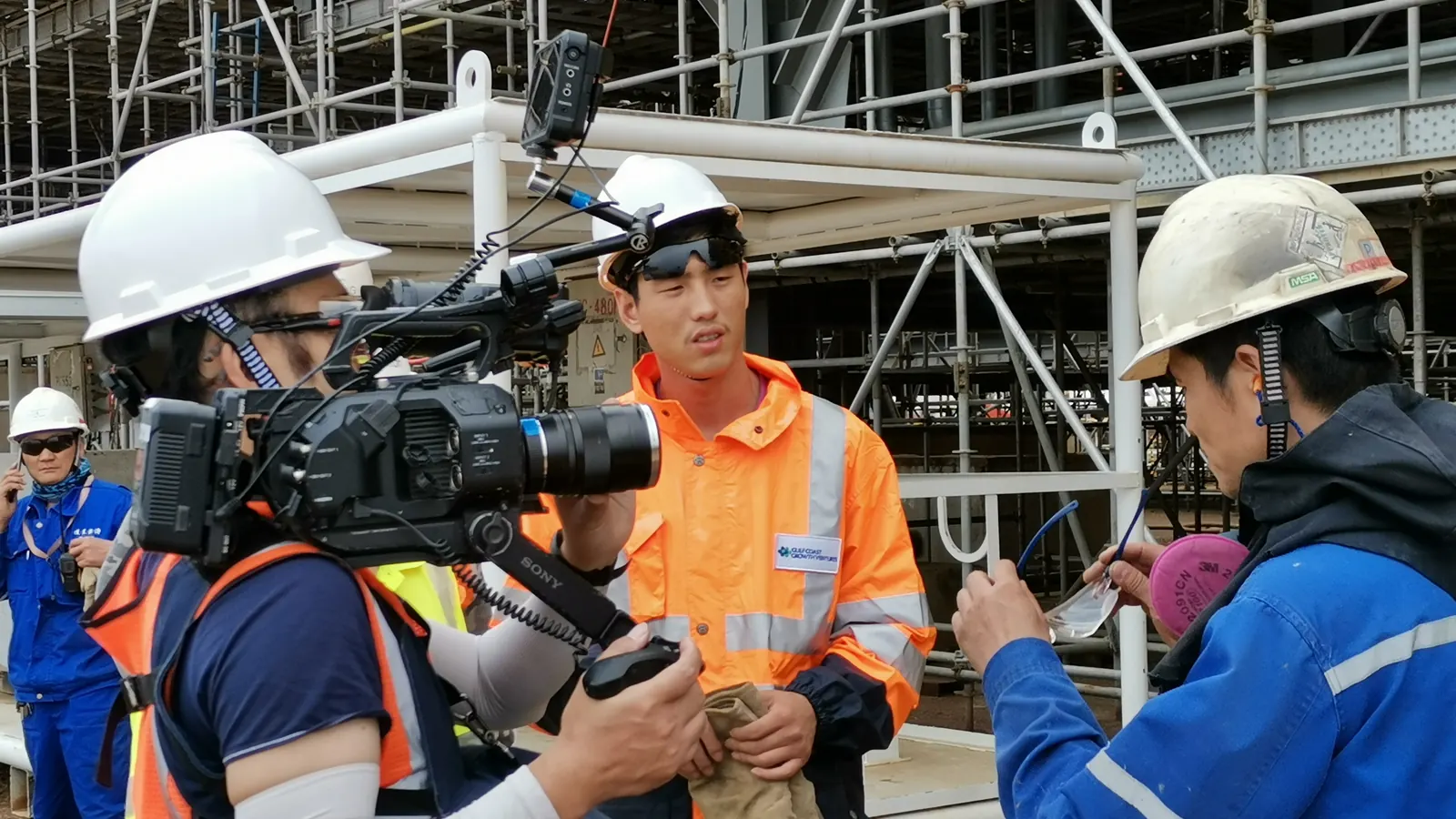 Camera crew filming at an industrial facility in China